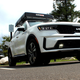 A photo of a white Kia Sorento SUV charging at a public plug.